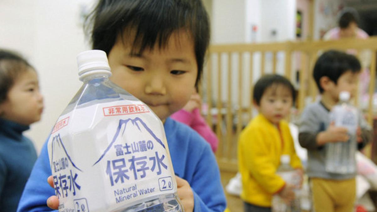 Un niño sostiene una botella de agua embotellada, este jueves, en una guardería en Tokio.