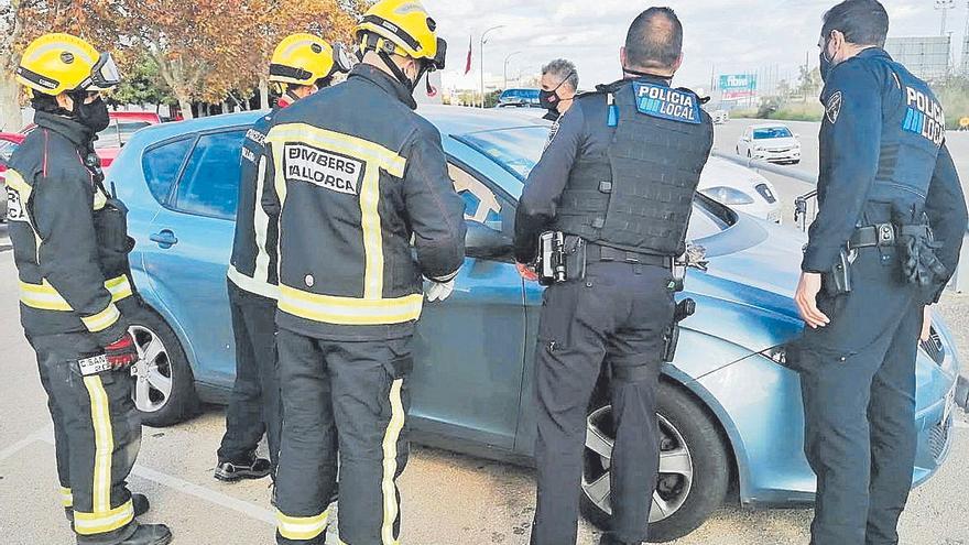 Policías y bomberos, durante el rescate de un niño y un perro en un coche.