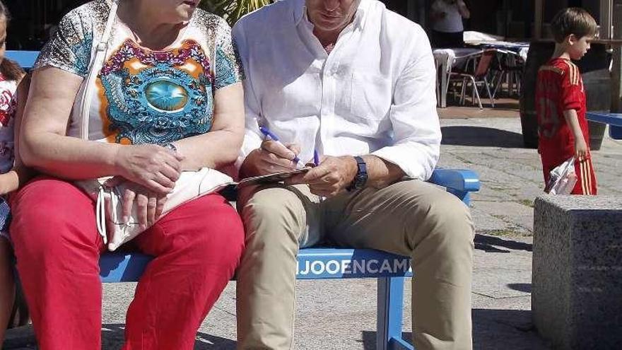 Feijóo habla con los ciudadanos de &quot;tú a tú&quot; en un banco azul