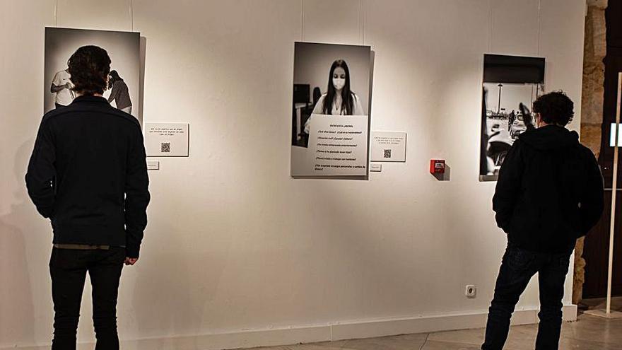 Dos visitantes observan las fotografías de la exposición.