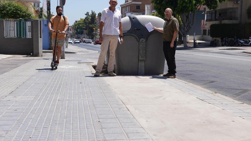 El portavoz de Adelante Málaga, Eduardo Zorrilla y David Arrabalí, de Adelante Málaga, junto a unos contenedores que cortan el carril bici.