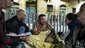 Carlos, voluntario de Arrels, habla con Navdeepsingh, antes de que la Guàrdia Urbana le expulse de esta plaza.