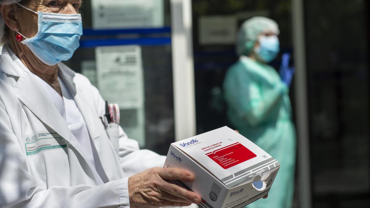 Una sanitaria sostiene una caja de test en el centro médico de A Cuña de Ourense. // Carlos Peteiro