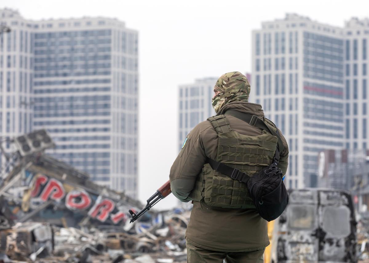 Imagen de archivo de un militar ucraniano junto a un centro comercial destruido en Kiev.