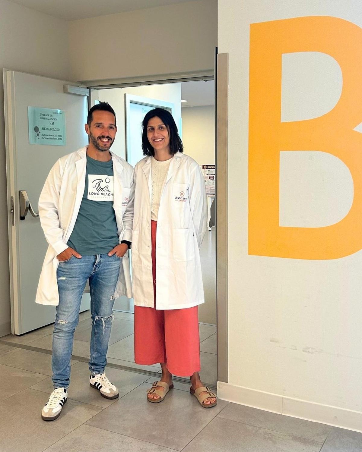 Manuel Estévez, con otra voluntaria de Asotrame, Lucía Amoedo, en el Hospital Álbvaro Cunqueiro de Vigo.