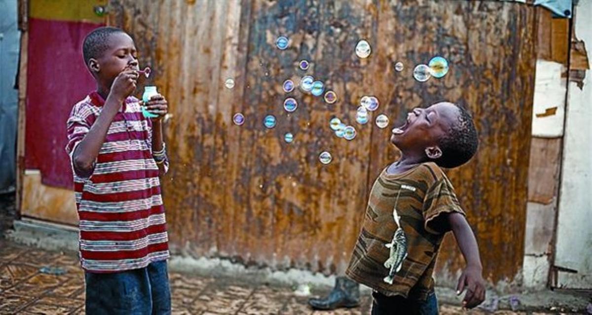 Foto de nens jugant amb bombolles, a la mostra ’Haití, 34 segons després’. Foto de nens jugant amb bombolles, a la mostra ’Haití, 34 segons després’.