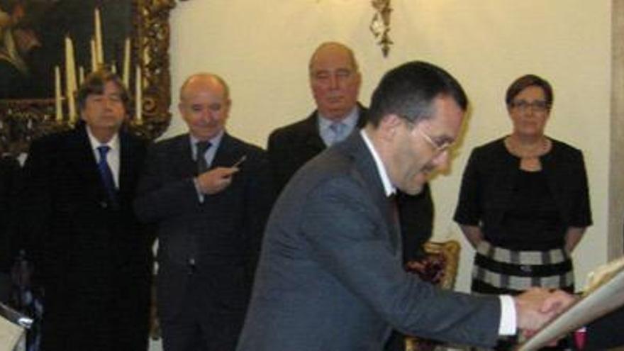 Torres Cantalapiedra firma su título de abogado rotal en un libro sujetado por el nuncio Renzo Fratini, el miércoles en Madrid.