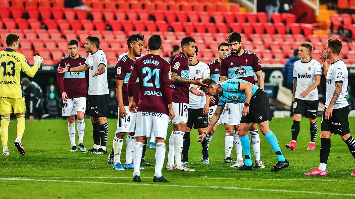 Rubén Blanco pide explicaciones a Maxi Gómez tras su expulsión,  mientras el árbitro señala el lugar de la falta