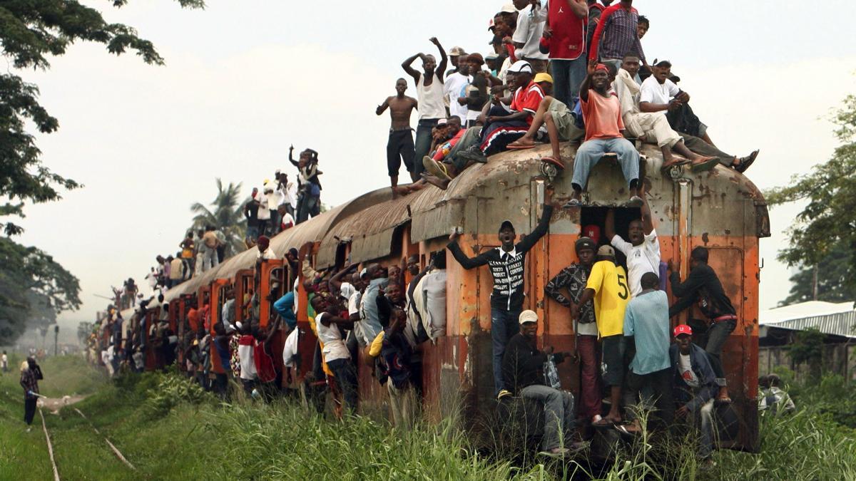 Congolese stand on top of a train as they travel in Kinshasa November 7, 2006. U.N. and European peacekeepers have bolstered their presence on the streets of Congo's capital Kinshasa to stem any violence as results trickle in from a presidential run-off vote. REUTERS/Goran Tomasevic (DEMOCRATIC REPUBLIC OF CONGO)