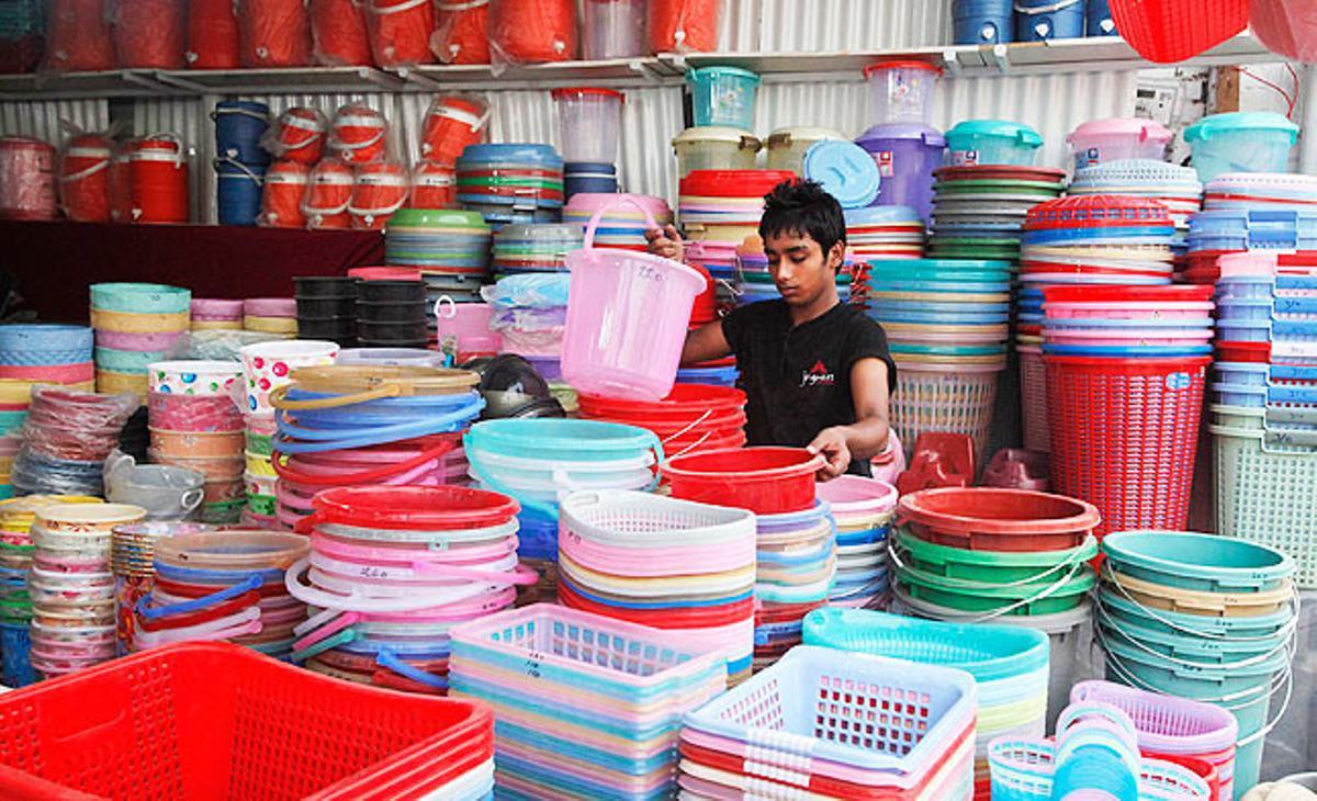 Un noi pakistanès ordena galledes i cistelles de plàstic en una botiga de la ciutat de Lahore.