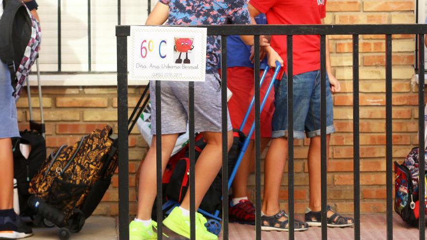 Varios niños aguardan la entrada al centro escolar.