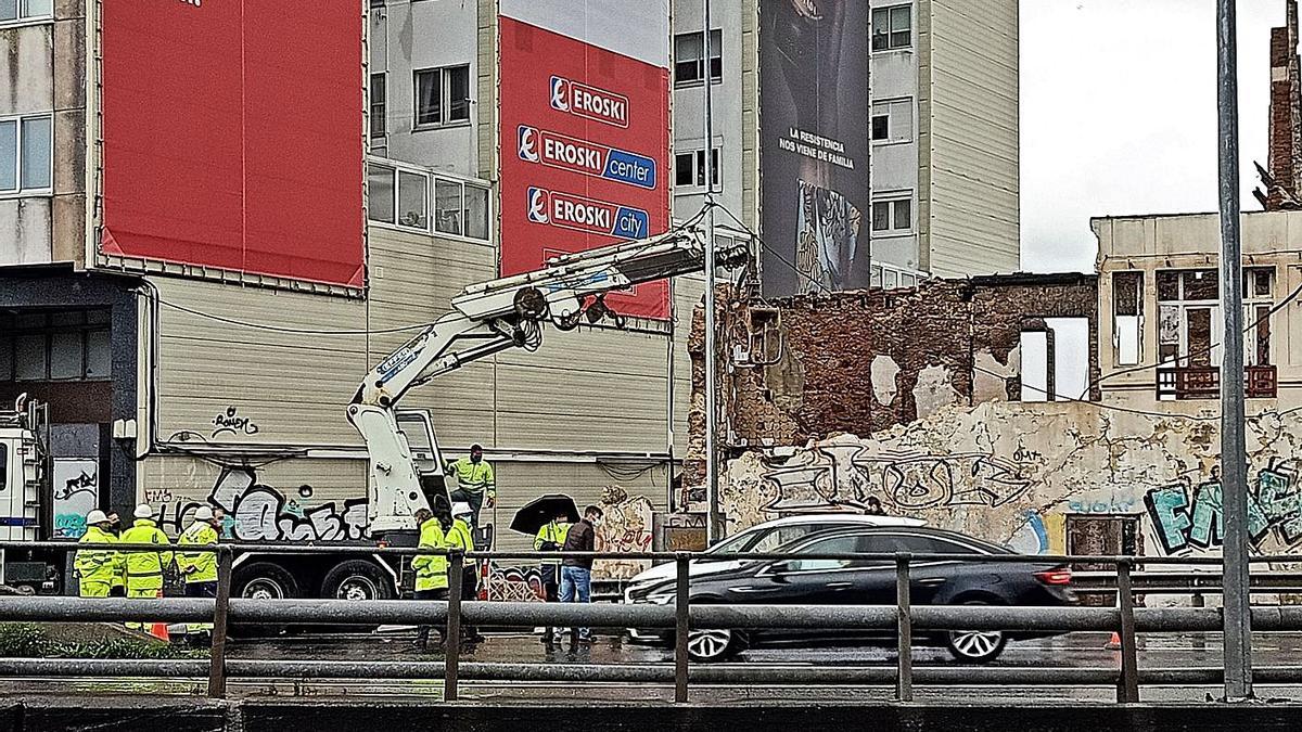 A la derecha, coche blanco de la policía autonómica y al lado un agente, ante la Casa Carnicero. |   // M.V.