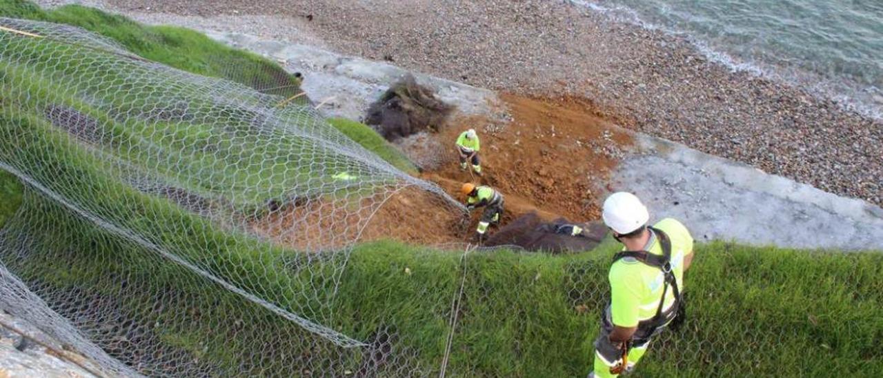 Operarios trabajando ayer en la limpieza del desprendimiento.