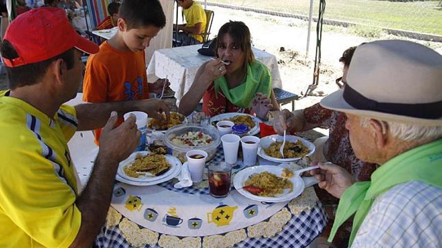 Un grupo de vecinos saborea la paella en el barrio de Pinilla.