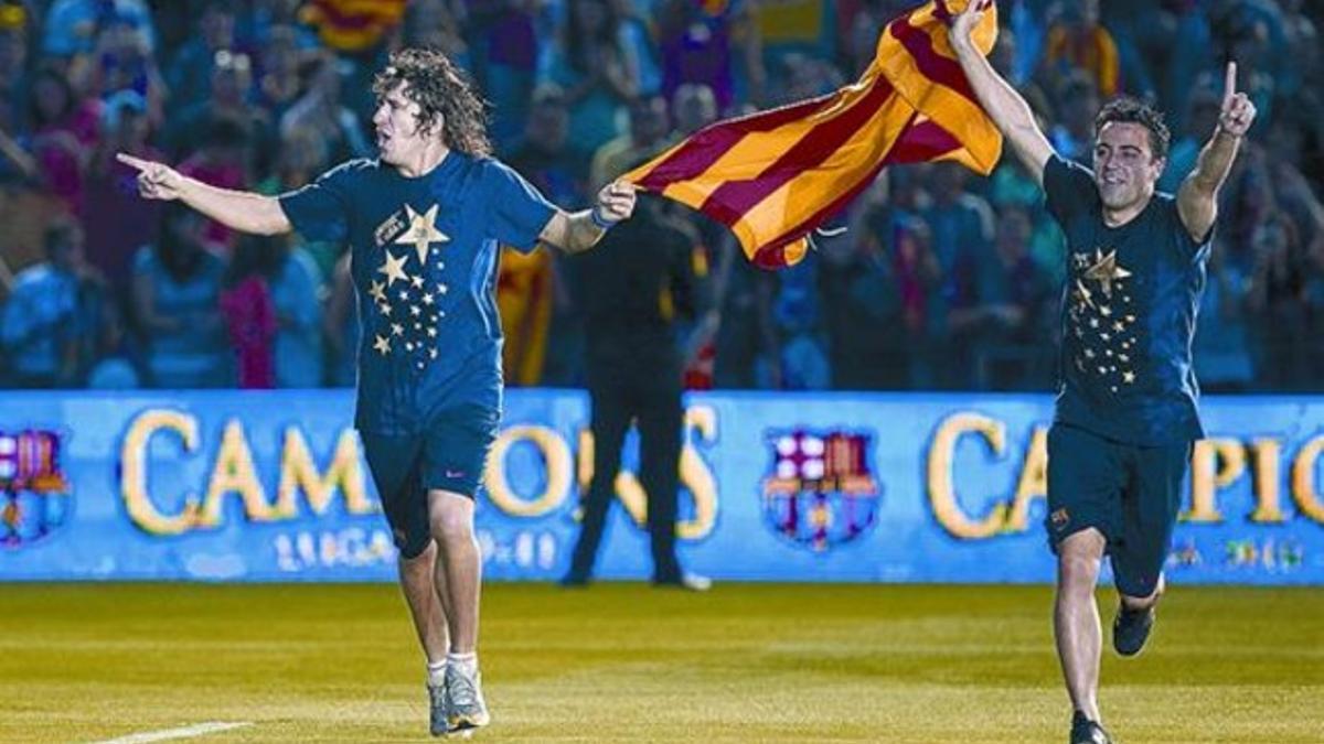 Puyol y Xavi lucen una 'senyera' durante la fiesta en el Camp Nou por la conquista de la Liga del 2011.