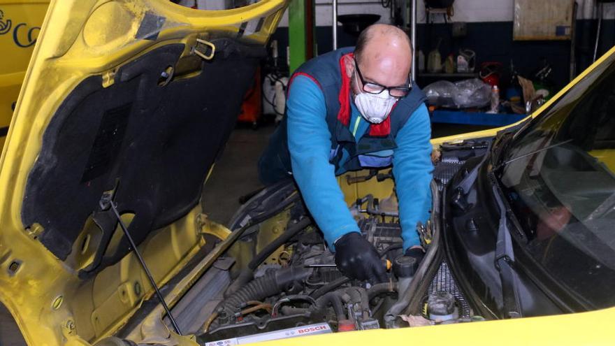 Un mecànic reparant una furgoneta de Correus a l&#039;interior del taller Reparacions Panella de Riudellots de la Selva.