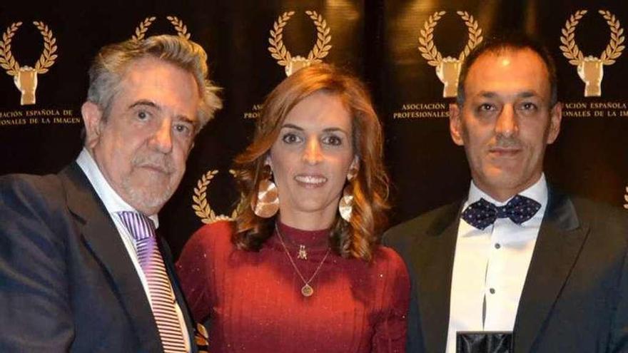 El modisto Petro Valverde entrega el certificado del premio a Ana Ledo y a Eduardo Vigo (dcha.) en una cena de gala en Madrid. // D.P.