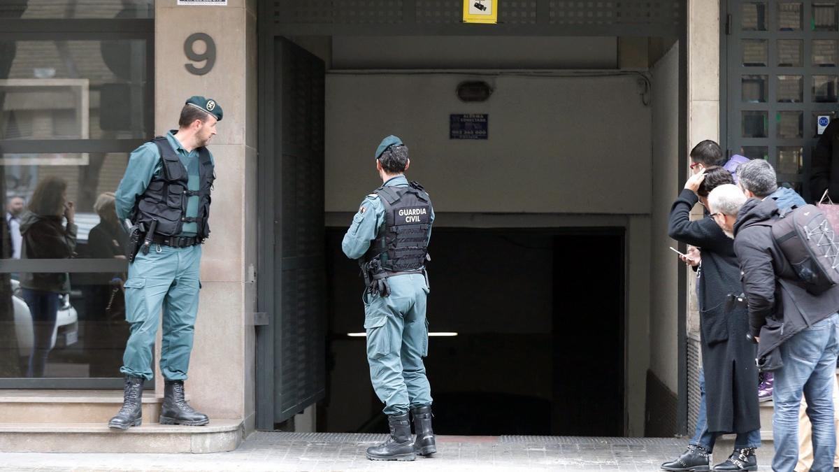 Agentes de la Guardia Civil y periodistas esperan la salida del vehículo de un investigado de su garaje durante una de las tres operaciones policiales del caso Azud.