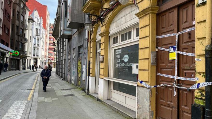 El número 3 de la calle del Carmen, precintado por la Policía Nacional, y, al fondo, el antiguo bloque okupa.