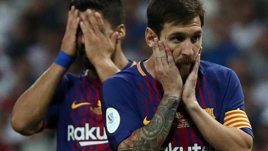 Messi se echa las manos a la cara con Luis Suárez tras él.