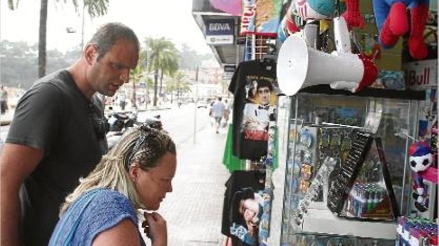 Turistes mirant articles a les botigues del passeig de Lloret, on es venen els darrers megàfons.