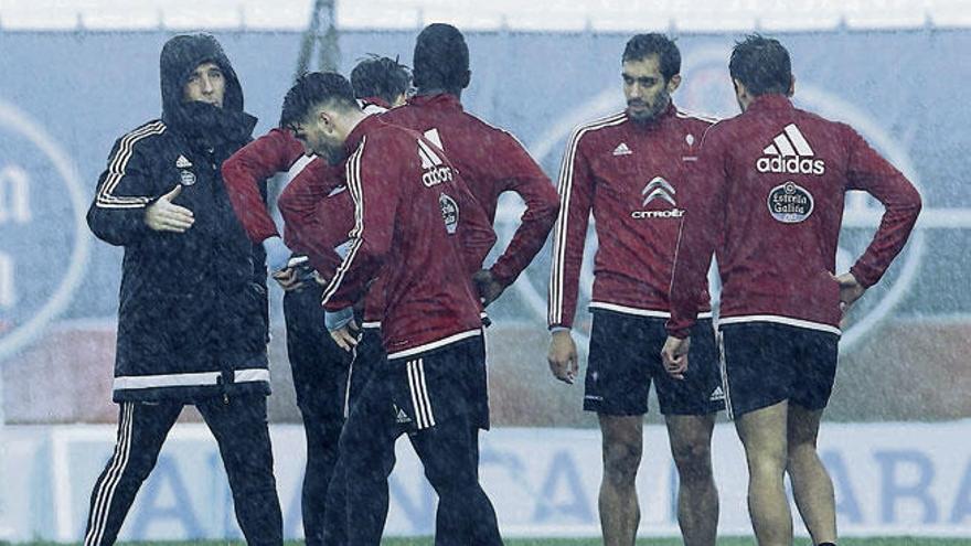 Eduardo Berizzo, a la izquierda con capucha, da instrucciones a sus jugadores durante el entrenamiento de ayer en A Madroa. // José Lores