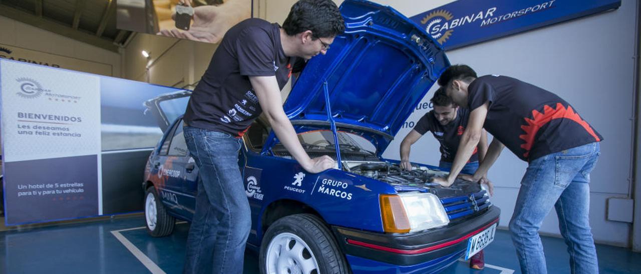 Los estudiantes de la UMH Alfonso Ases, Borja Gallud y Manuel Arnau preparan el coche con el que participarán en la prueba.