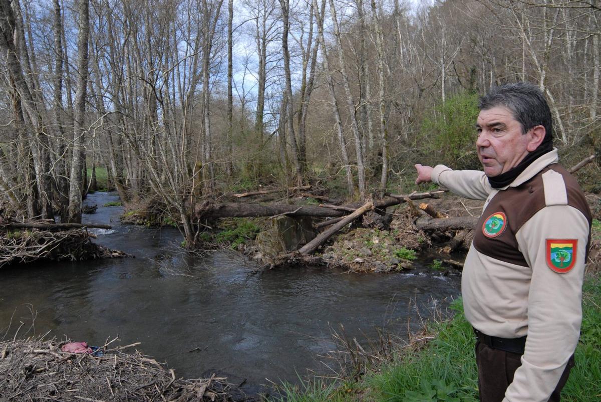 El guarda de la Sociedad de Caza de Lalín junto al meandro artificial pendiente de reparar desde hace cinco años, en una finca privada. | BERNABÉ/JAVIER LALÍN