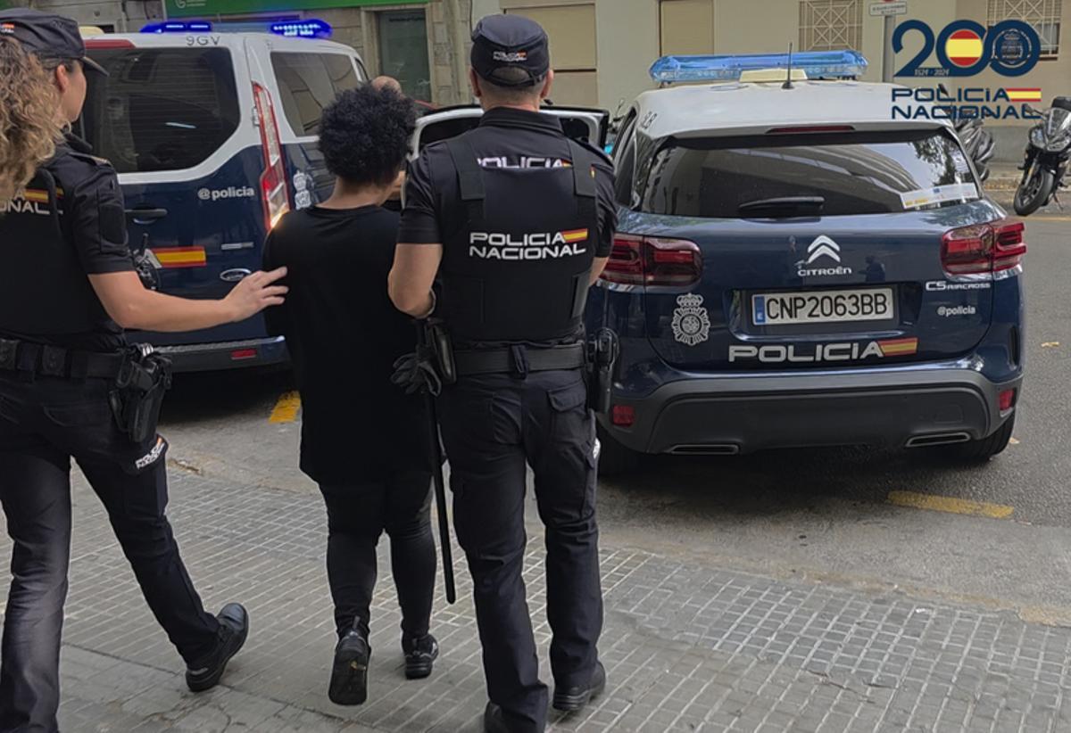 Agentes de la Policía Nacional llevan detenida a una de las presuntas estafadoras del anciano.