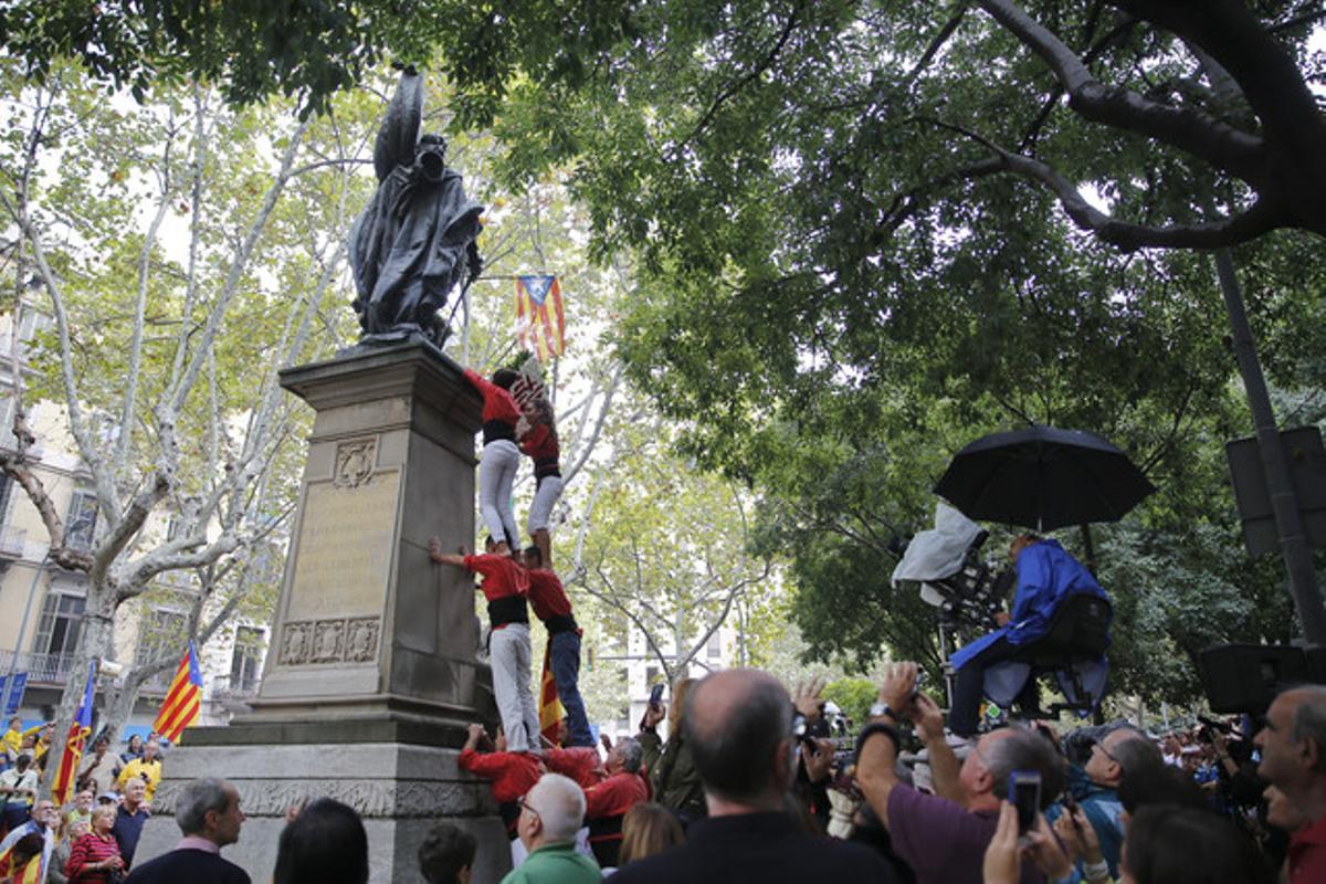 Los Castellers de Barcelona han subido a lo más alto del monumento para colocar su ofrenda.