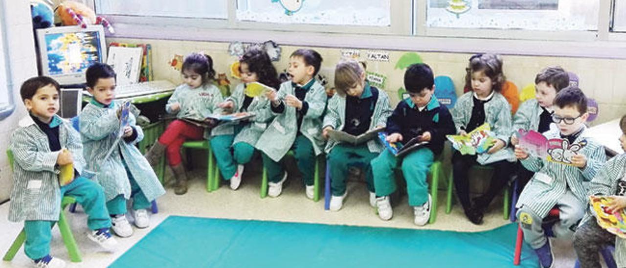 Escolares de Infantil leyendo en su aula cuentos de su biblioteca.