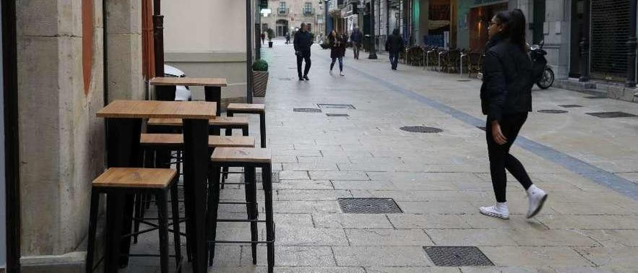 Mesas pegadas a una fachada en un establecimiento de la calle La Fruta.