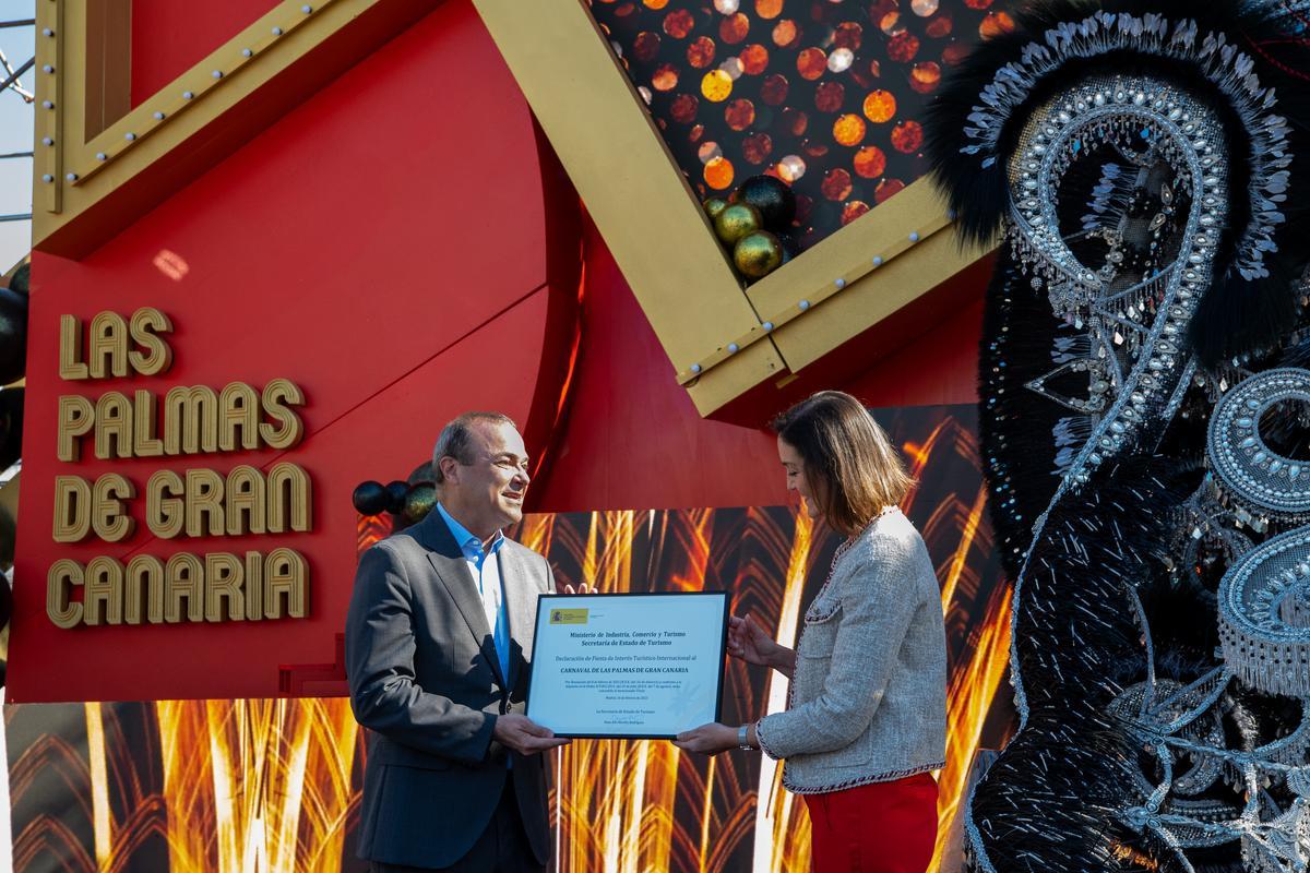 La ministra Reyes Maroto entrega a Augusto Hidalgo la distinción del Carnaval como Fiesta de Interés Turístico Internacional.