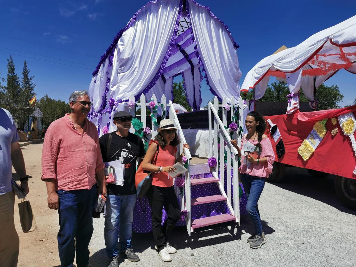 Irene de Miguel y Joaquín Macías, junto a parte del equipo, posan junto a una carroza morada.