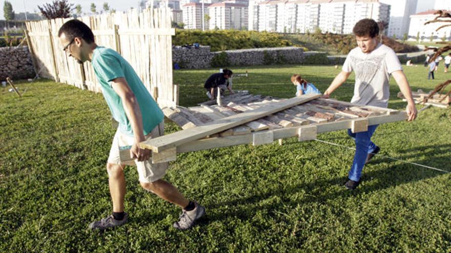 Trabajos para la construcción del campamento romano, ayer, en el parque de Navia. // J. Lores