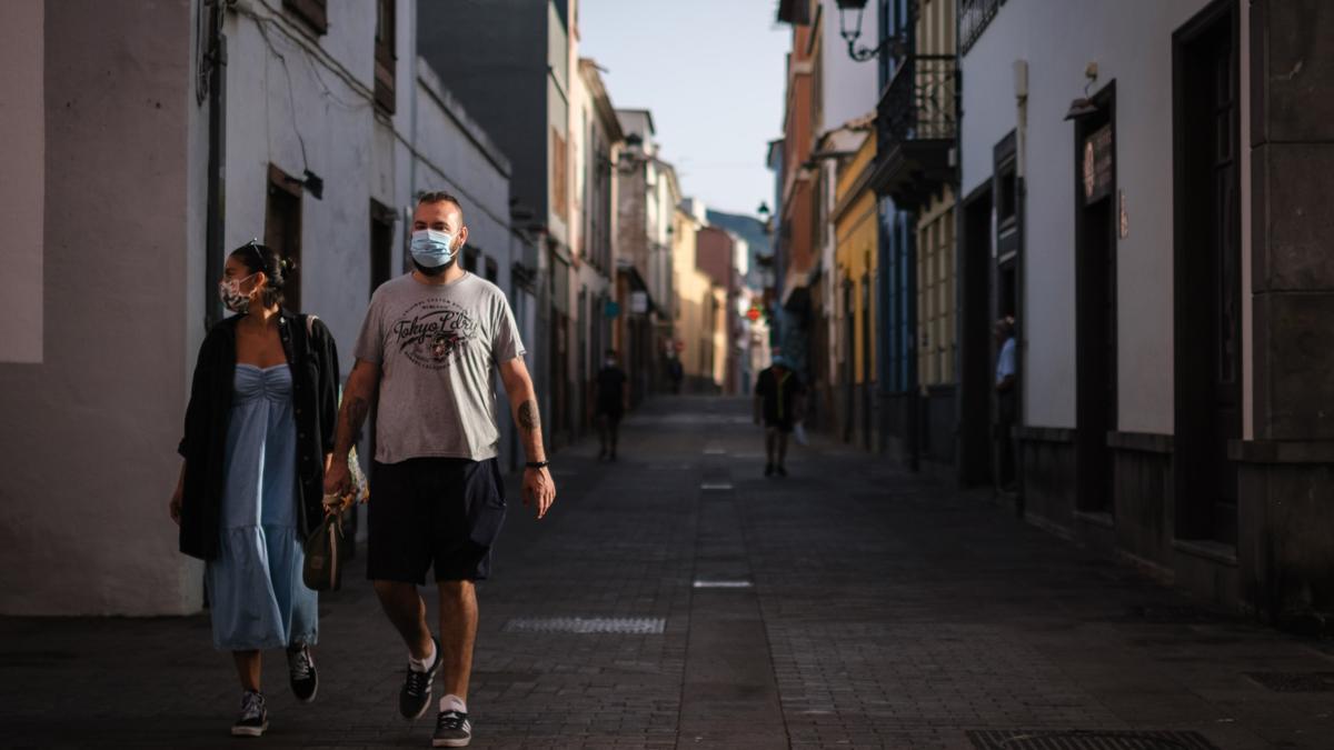 Una pareja con mascarilla pasea por las calles de La Laguna.