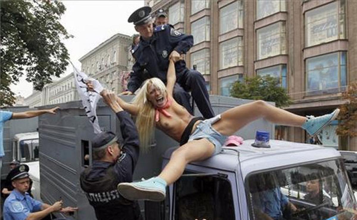 Dos policies ucraïnesos detenen una activista del grup feminista FEMEN, que es manifestava a les portes d’un tribunal de Kíev (Ucraïna).