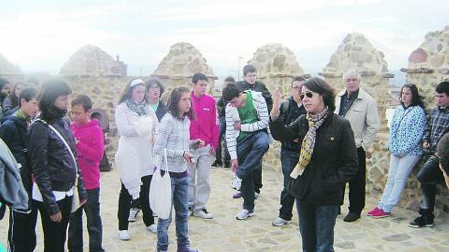 A la izquierda, visita a la muralla de Ávila; a la derecha, la delegación asturiana, en la sede de la Diputación Provincial abulense.