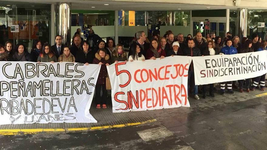 Participantes en la protesta para reclamar pediatras y mejoras en las condiciones laborales de los trabajadores de Urgencias, con sus pancartas a la entrada del Hospital de Arriondas, ayer.