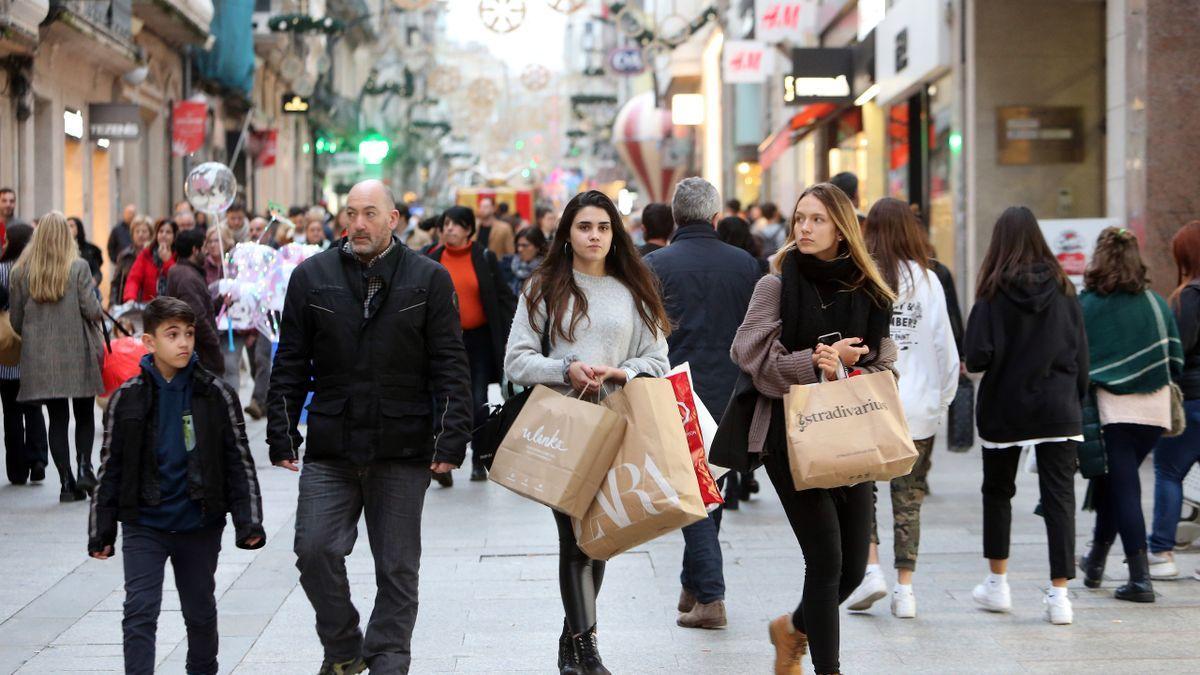 Gente paseando con bolsas de Zara y Stradivarius