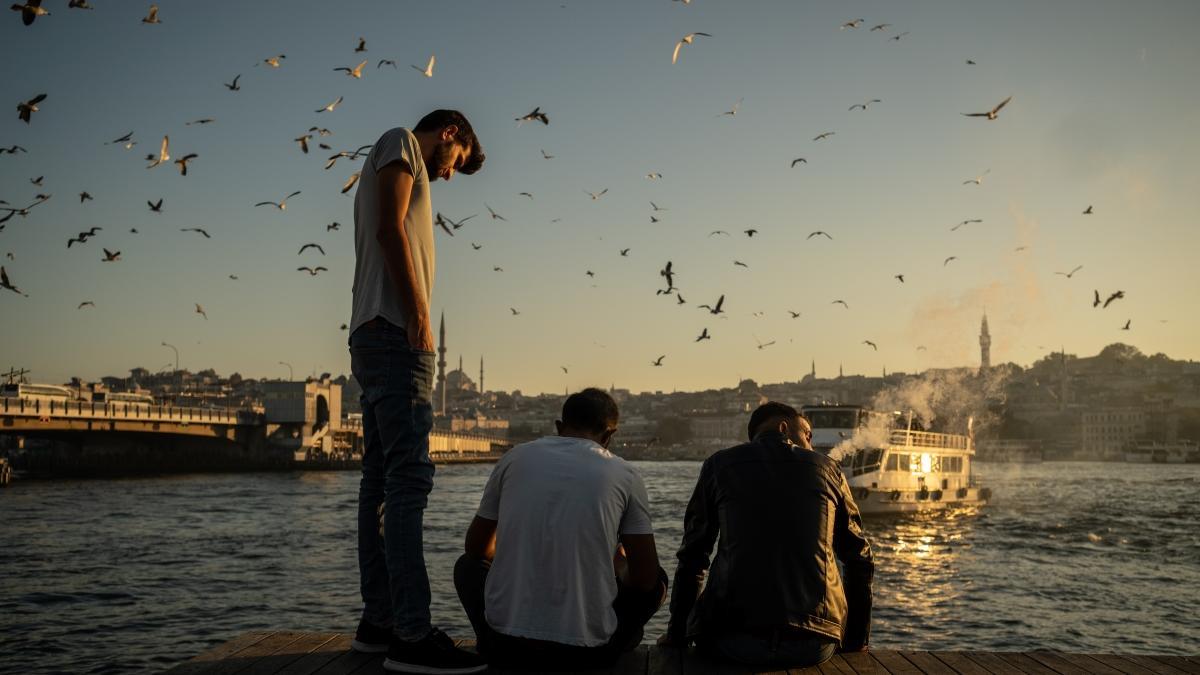 Jóvenes turcos en un muelle con la ciudad al fondo