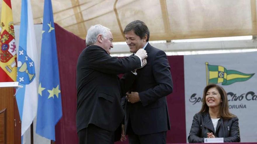 José Manuel Rodríguez, presidente del Centro Asturiano de La Coruña, impone la insignia de oro a Javier Fernández. Detrás, la consejera de Medio Ambiente de la Xunta de Galicia, Beatriz Mato.