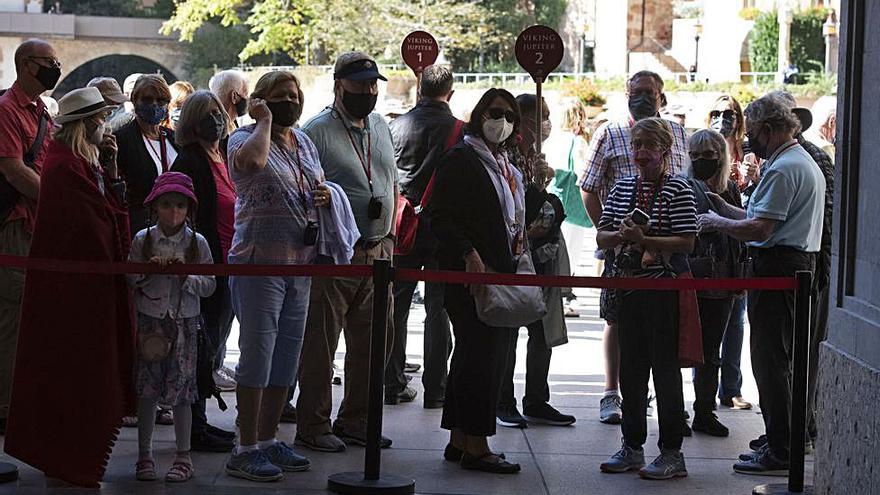 Un grup de turistes observa la processó de sortida de la basílica | OSCAR BAYONA