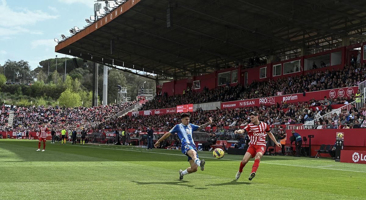 Miguel centra ante Ruben durante el partido de liga en Montilivi 