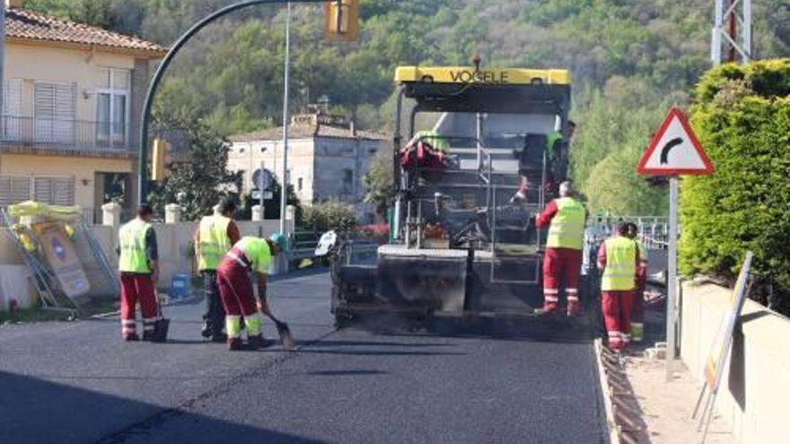 Operaris treballen en la pavimentació del pont del Salt.