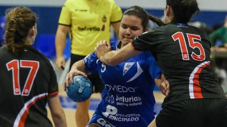 Mada, del Ansa Oviedo, entre dos jugadoras del Gijón Balonmano.