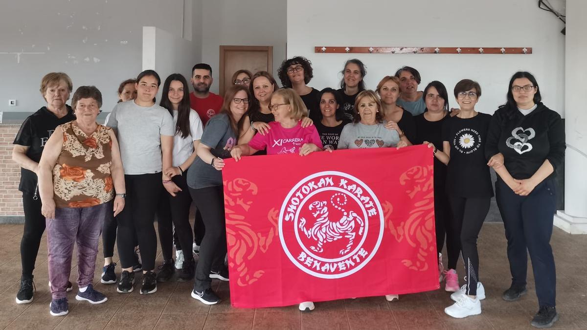 Mujeres participantes en el curso posan con el monitor que imparte el taller de defensa personal.