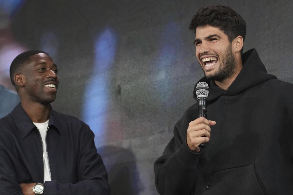 Carlos Alcaraz sonríe junto a Dembelé durante el sorteo del cuadro final de Roland Garros