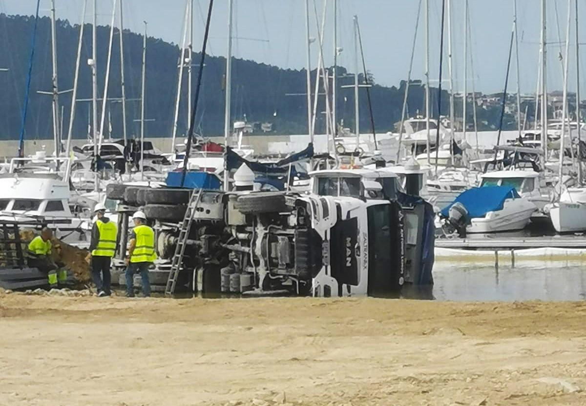 Camión volcado en el relleno del puerto de Baiona.