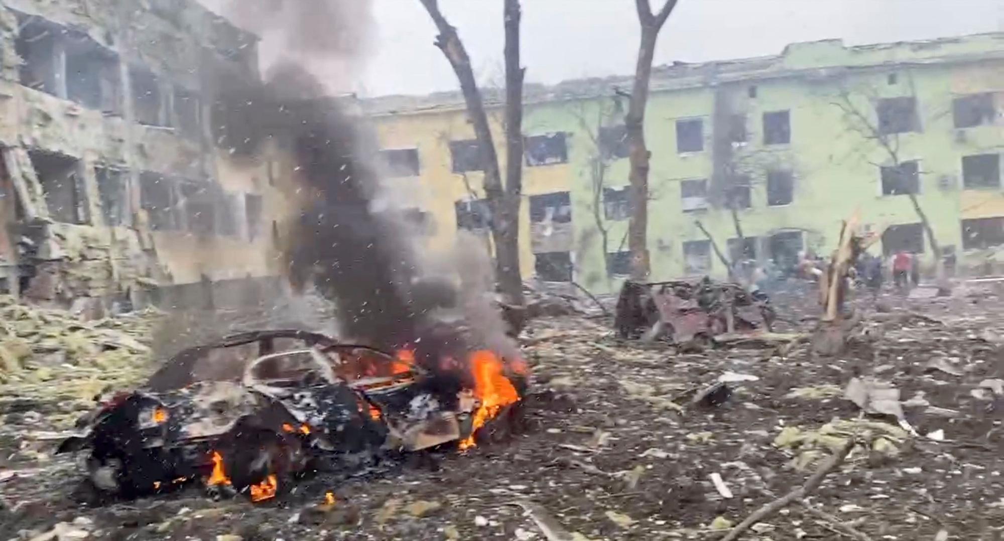 Un coche arde a las puertas del hospital bombardeado en Mariúpol.